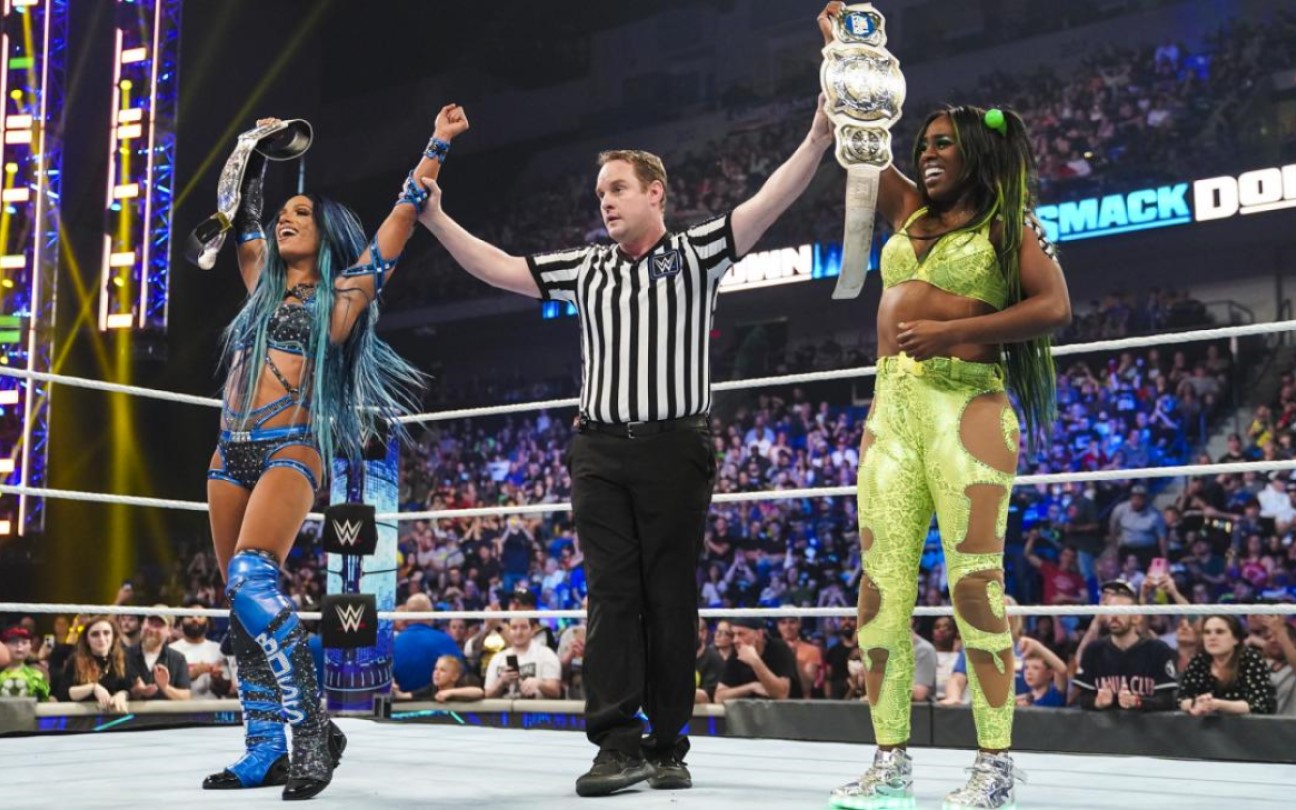 Sasha Banks e Naomi celebram a vitória com o árbitro da WWE