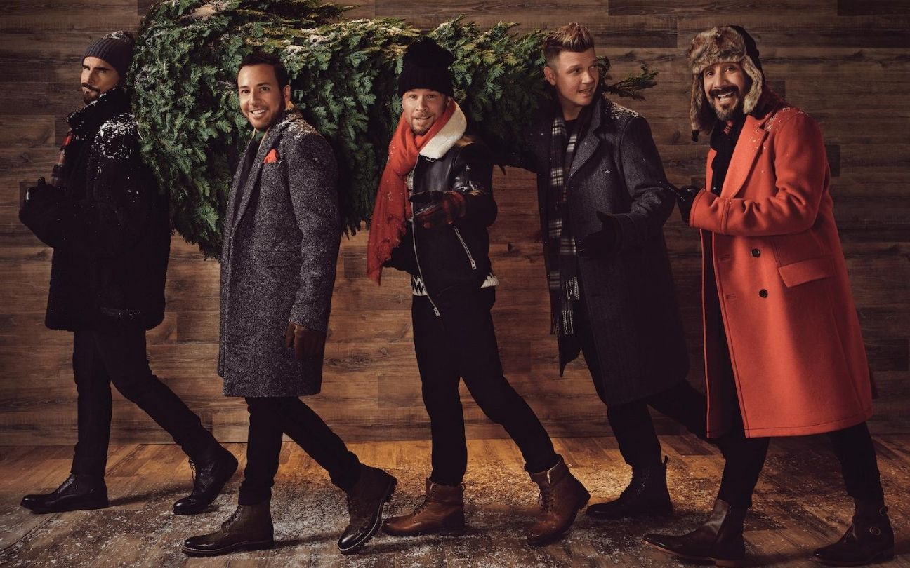 Backstreet Boys em fila, segurando árvore de Natal