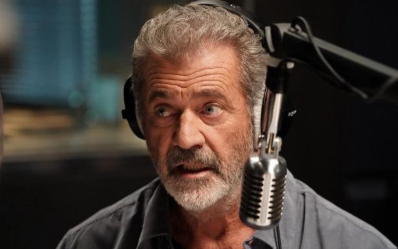 Mel Gibson com um fone de ouvido e um microfone