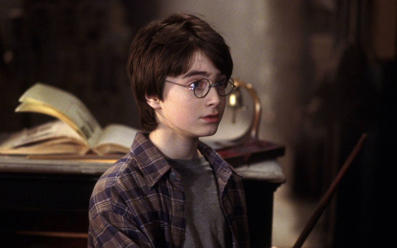 Daniel Radcliffe em cena de Harry Potter e a Pedra Filosofal; filme tem outono como pano de fundo